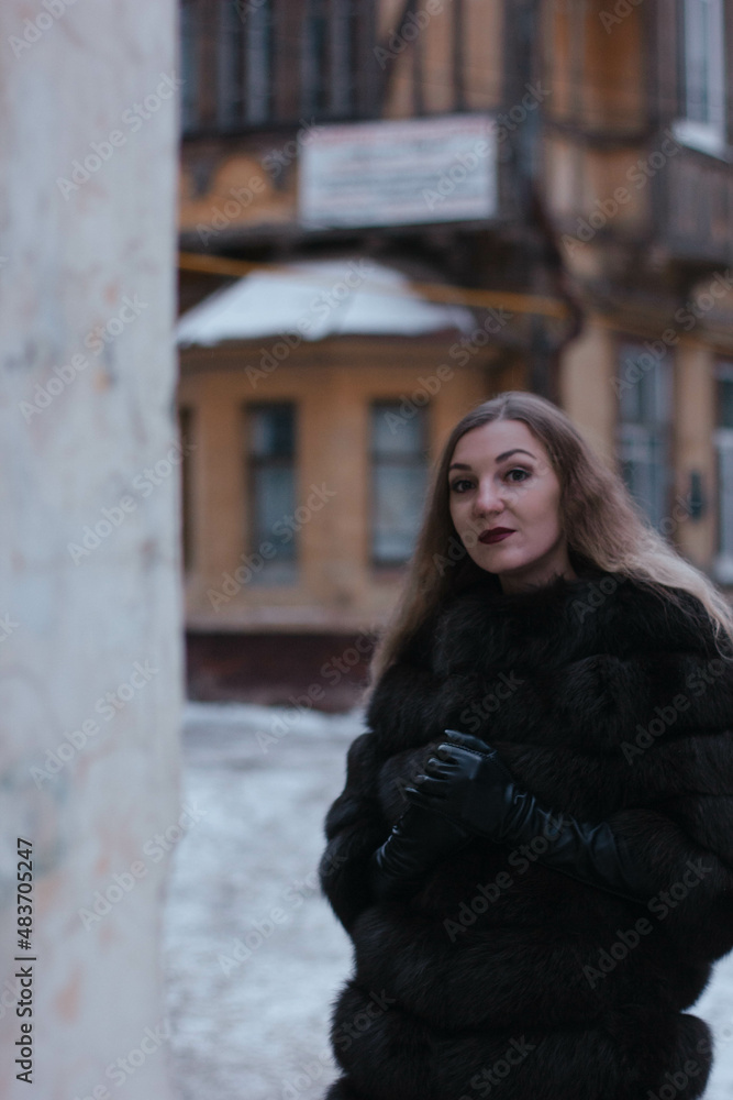 portrait of a white girl in winter in a fur coat who walks through the streets of the city portrait of a white girl in winter in a fur coat who walks through the streets of the city