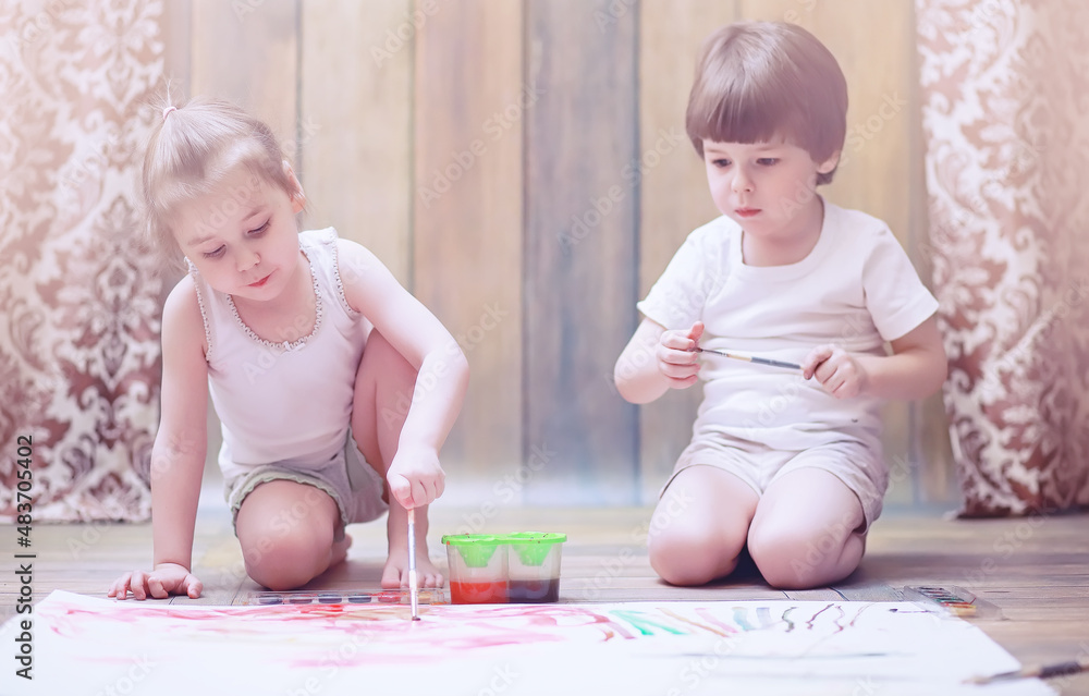 Little children paint on a large sheet of paper Little children paint on a large sheet of paper