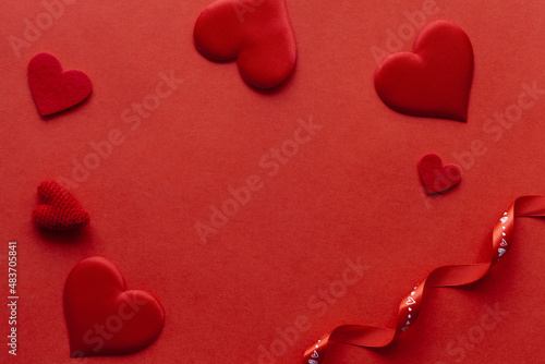 Red background with red hearts and ribbon. St. Valentine day card.