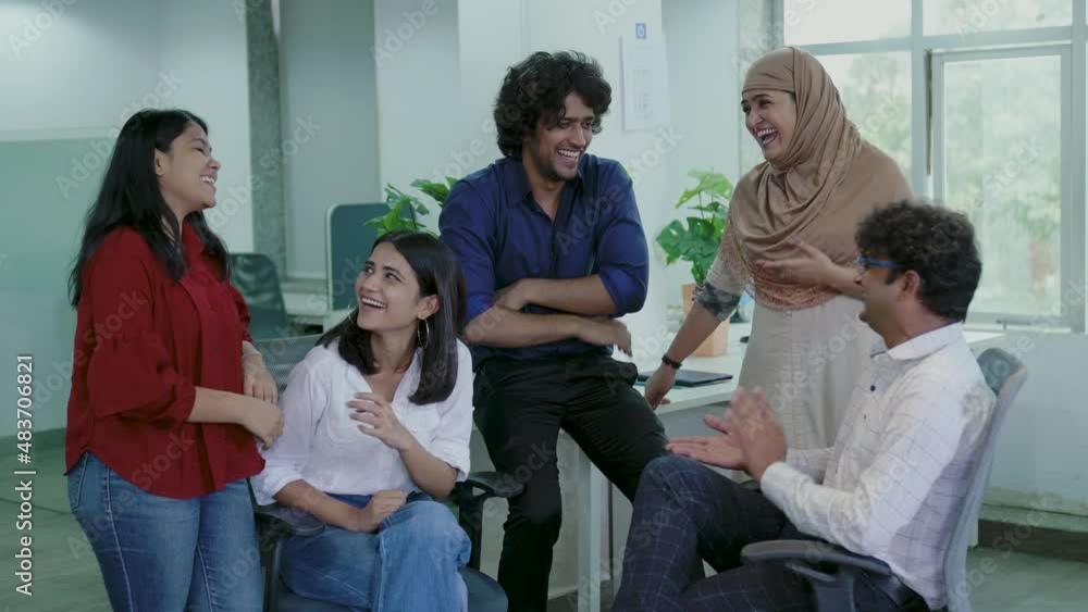 Diverse young Indian Group of Talented Business People Chatting, Joking and Having Fun on office room. Stylish Young People in Modern Office. Diverse young Indian Group of Talented Business People Chatting, Joking and Having Fun on office room. Stylish Young People in Modern Office.