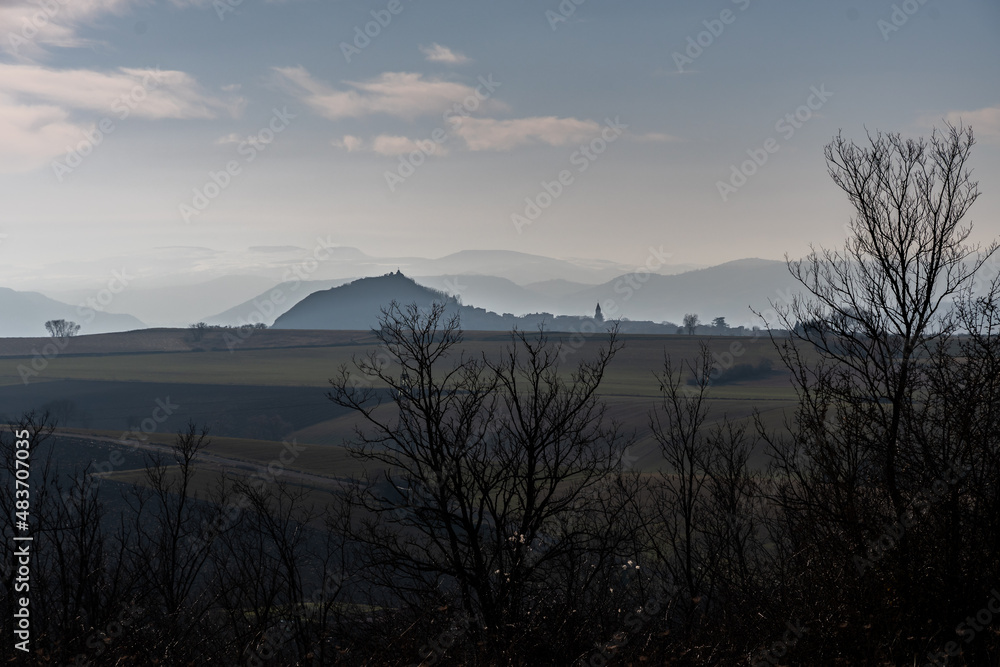 Paysage d'Auvergne avec des montagnes au loin baignées par de la brume le matin