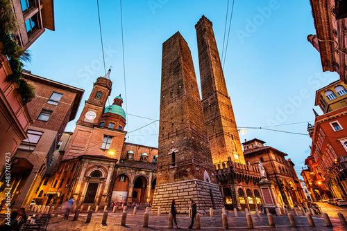 Two famous falling Bologna towers Asinelli and Garisenda. Evening view, long exposure. Bologna, Emilia-Romagna, Italy.