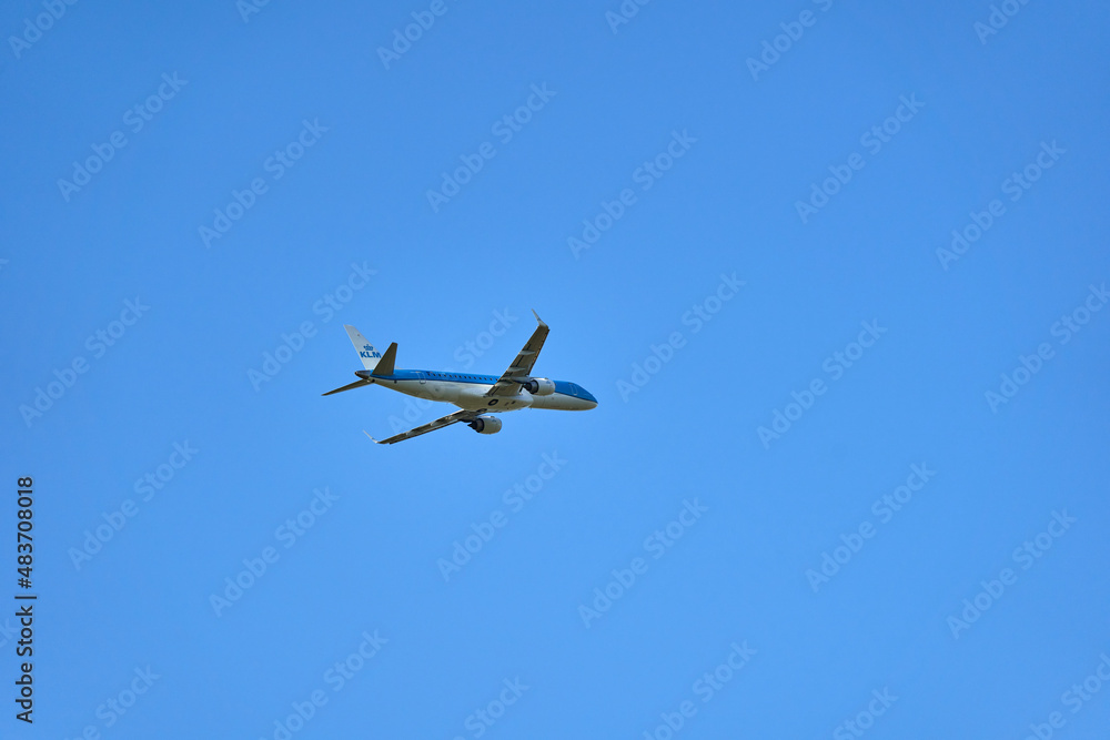 Fototapeta premium Aircraft of the company KLM after takeoff. Single flying object in front of blue sky. Up view.