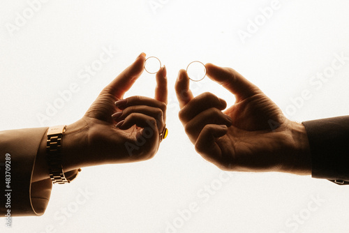 two hands of people in love are holding wedding rings