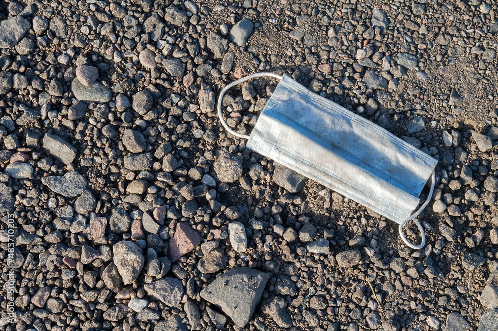Trash on the road. Medical mask lying on the ground. Pollution of nature by household waste. Trash on the road. Medical mask lying on the ground. Pollution of nature by household waste.