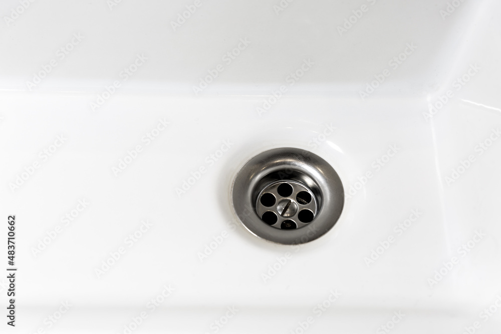 Drain in a white sink, background, close-up Drain in a white sink, background, close-up