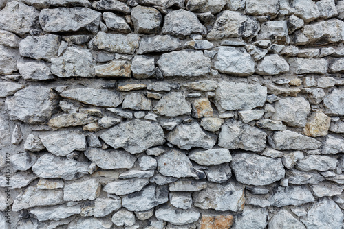 Fragment of an old gray stone wall old gray masonry