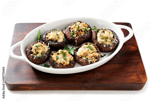 Baked mushroom caps stuffed with chicken meat, parmesan cheese, garlic and herbs. isolated on white background. 