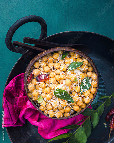 Southindian Chickpeas salad garnished with coconut, curry leaves and dried red chilli photo