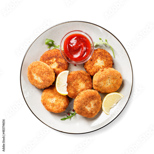 Chicken patties or fish cakes fried in breadcrumbs with ketchup and lemon slices. isolated on white background, top view
