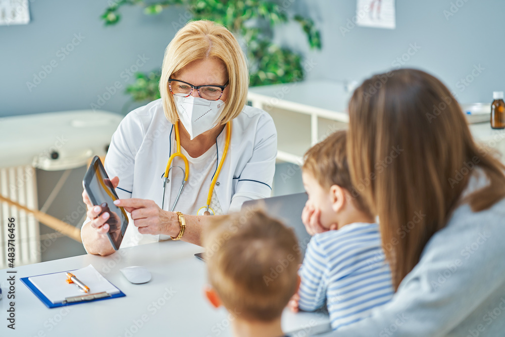 Pediatrician doctor examining little kids in clinic Pediatrician doctor examining little kids in clinic