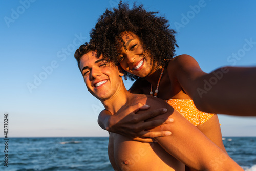 Positive fun self portrait of young traveling couple in love - having fun on amazing tropical beach - Happy traveling couple making selfie - sunny summer colors - romantic mood - happy couple at the b
