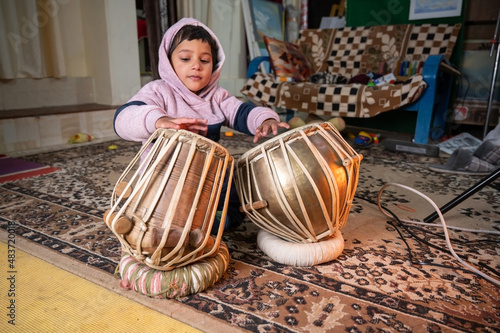 Konstfotografi a small child trying to learning to play the tabla .