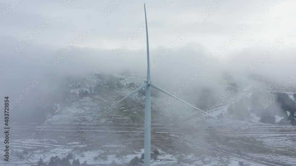 Wind turbine in a snowy landscape with early winter morning mist. Wind turbine in a snowy landscape with early winter morning mist.