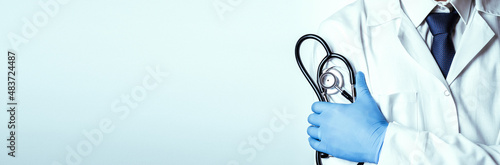 Stethoscope doctor medical background. Happy nurse in hospital uniform, blue gloves holding stethoscope isolated on white. Medicine service and healthcare concept.