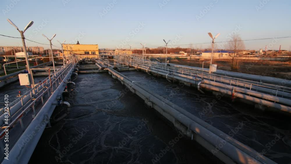 Waste water aeration in large basins with pipeline system at contemporary filtration station at autumn sunset light Waste water aeration in large basins with pipeline system at contemporary filtration station at autumn sunset light