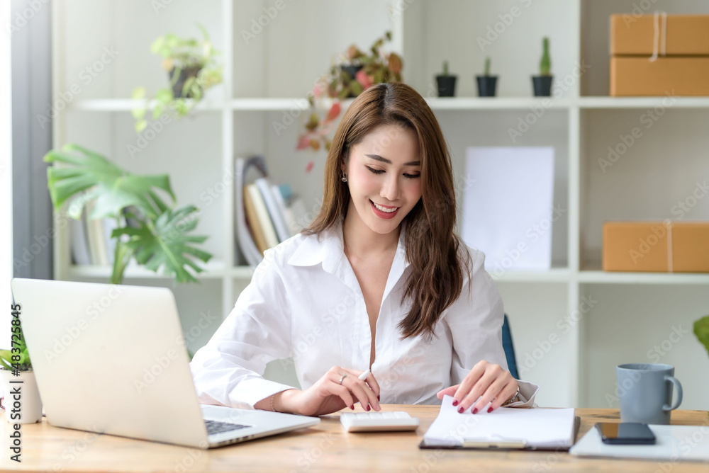 Confident young Asian businesswoman sitting working at her workplace at modern office. Confident young Asian businesswoman sitting working at her workplace at modern office.