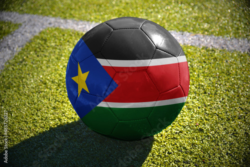 football ball with the national flag of south sudan lies on the green field