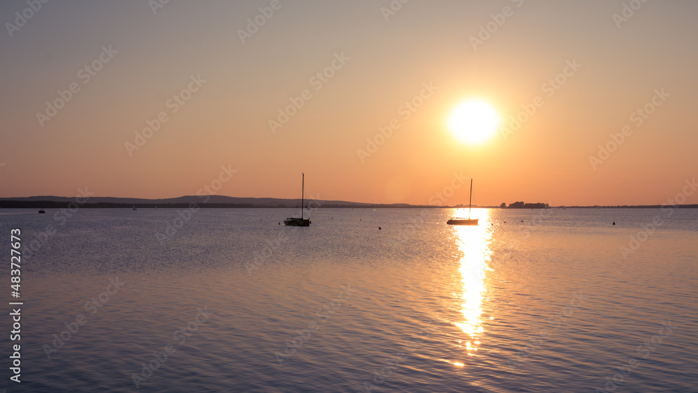Two boats lonely on the lake at sunset Two boats lonely on the lake at sunset