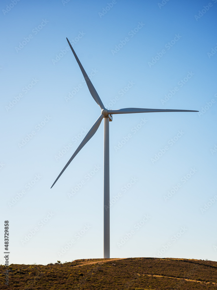 Wind turbines on a beautiful blue sky in a mountain wind farm in Sardinia. Renewable energy concept, green energy generation. Energy industry. Wind turbines on a beautiful blue sky in a mountain wind farm in Sardinia. Renewable energy concept, green energy generation. Energy industry.