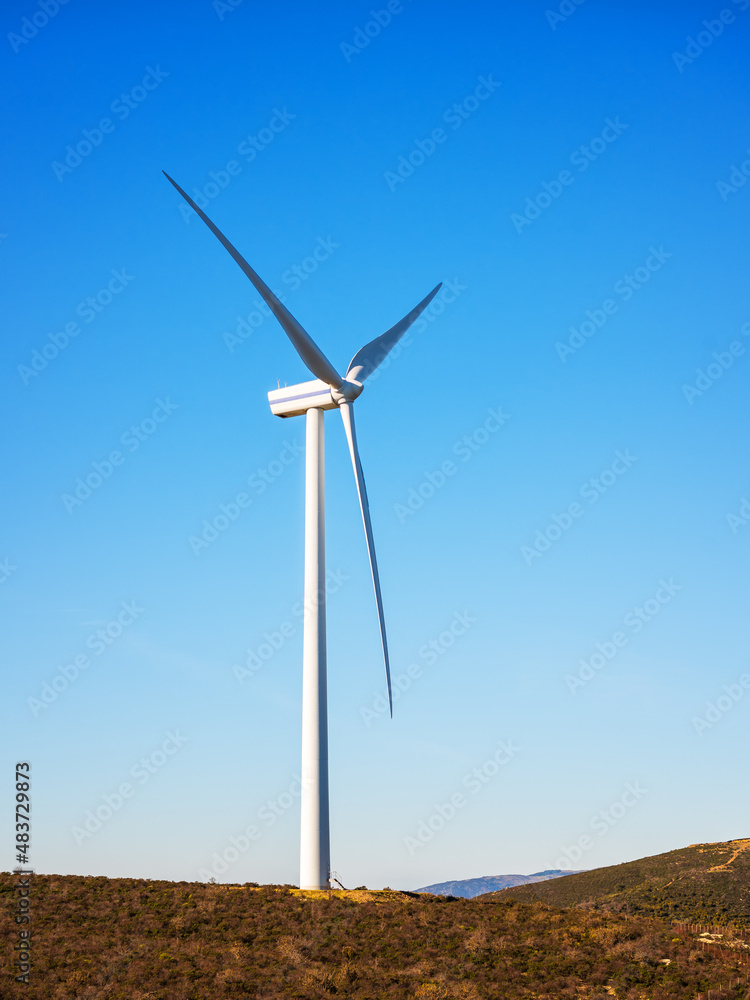 Wind turbines on a beautiful blue sky in a mountain wind farm in Sardinia. Renewable energy concept, green energy generation. Energy industry. Wind turbines on a beautiful blue sky in a mountain wind farm in Sardinia. Renewable energy concept, green energy generation. Energy industry.
