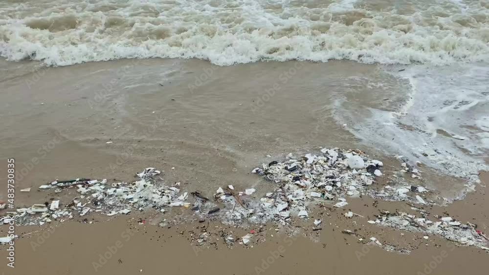 Small plastic particles, polystyrene and other pieces of rubbish wash around in the waves in the ocean. Cellphone video Small plastic particles, polystyrene and other pieces of rubbish wash around in the waves in the ocean. Cellphone video