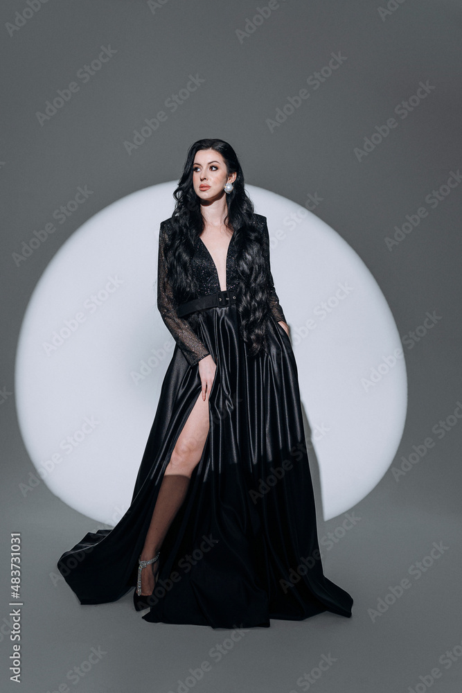 luxurious woman in an expensive evening dress in the light of a spotlight beam luxurious woman in an expensive evening dress in the light of a spotlight beam