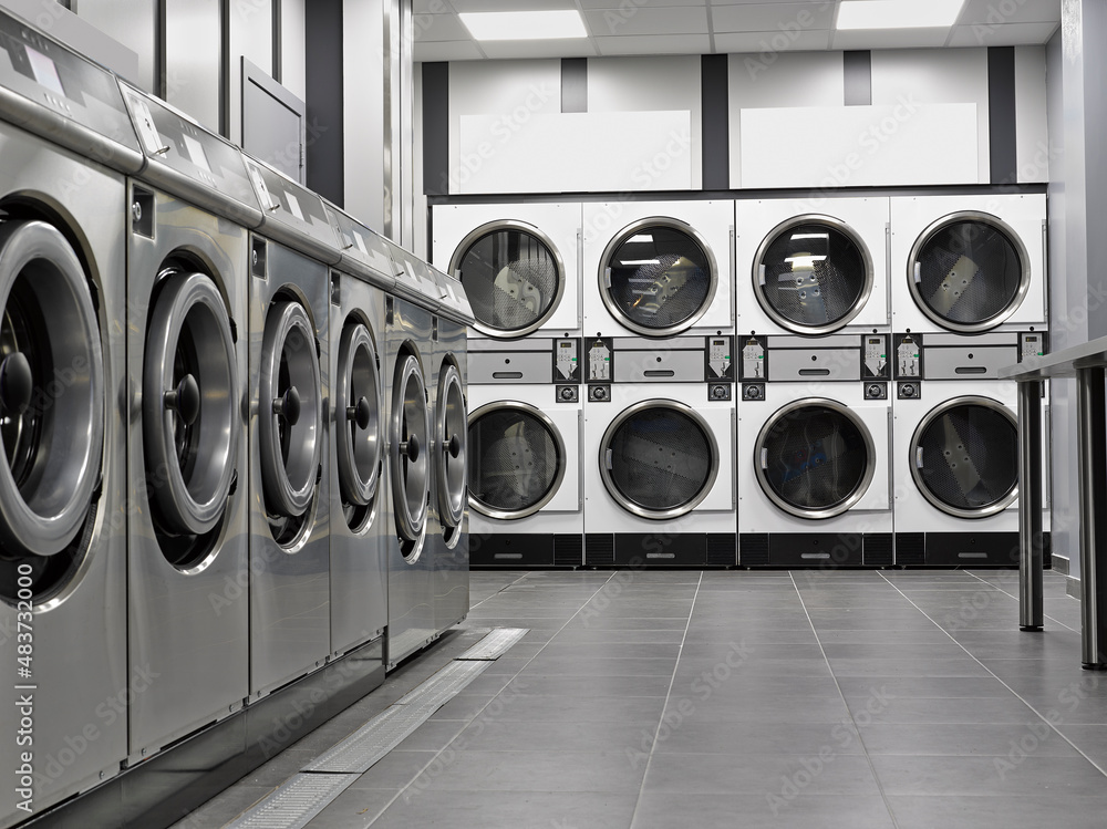 Row of industrial washing machines in a public laundromat