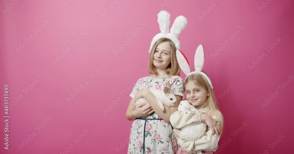 Cute Girls With Rabbit Ears Playing with the Rabbit on an Isolated Background Cute Girls With Rabbit Ears Playing with the Rabbit on an Isolated Background