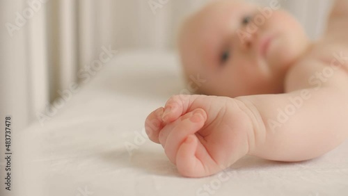 Close up hand of cute little child lying on bed relaxing having calmness emotion