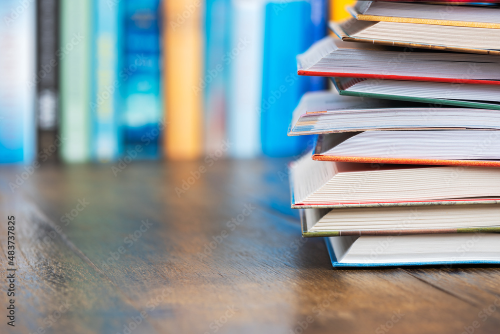 Stack opened book on wooden desk with blurred soft library background Stack opened book on wooden desk with blurred soft library background