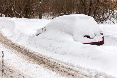 Snow-covered car on the side of the road