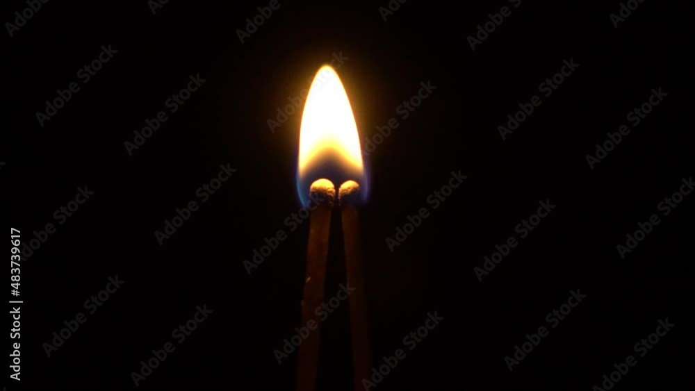 Two matches burn at the same time on a dark background Two matches burn at the same time on a dark background