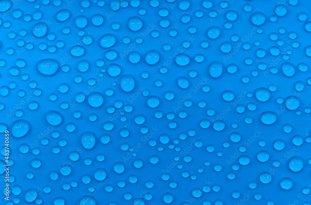 Water drops on a blue background close-up. Water on the surface