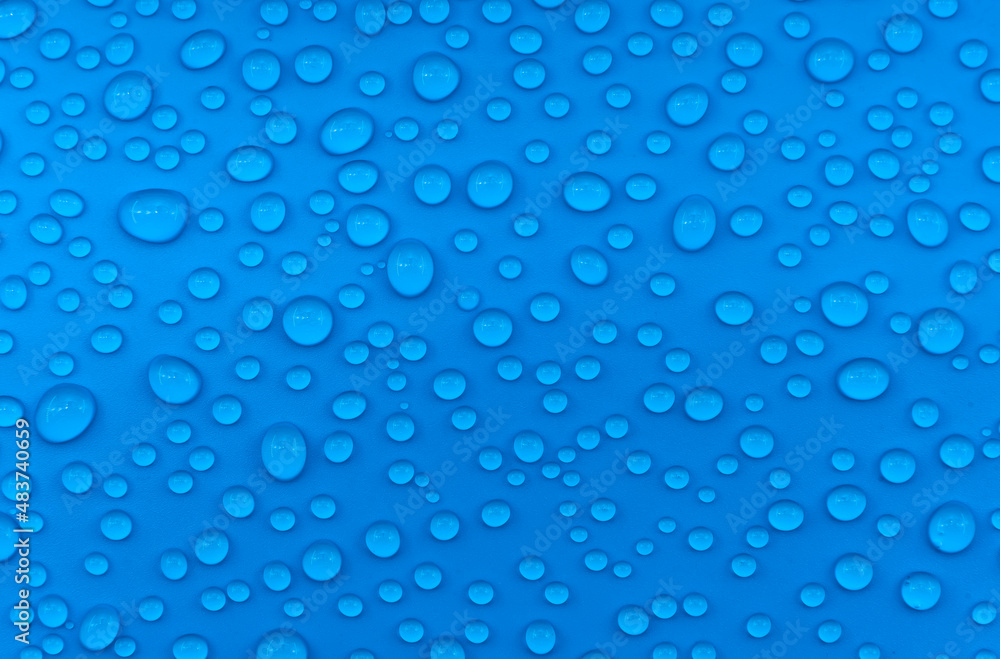Water drops on a blue background close-up. Water on the surface Water drops on a blue background close-up. Water on the surface