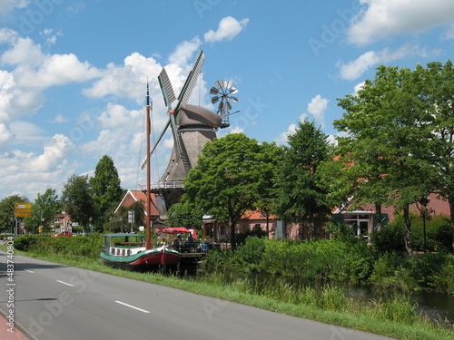 Galerieholländerwindmühle in Großefehn Ostfriesland am Entwässerungskanal mit Torfschiff