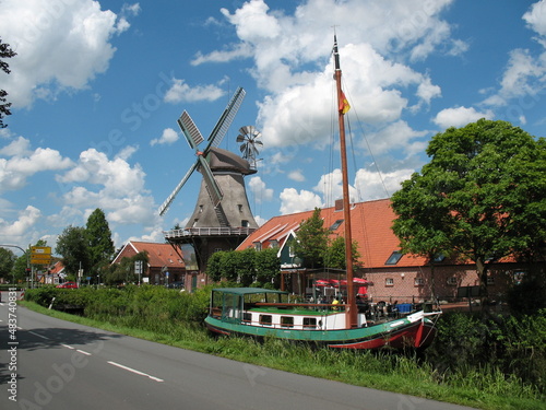 Galerieholländerwindmühle in Großefehn Ostfriesland am Entwässerungskanal mit Torfschiff