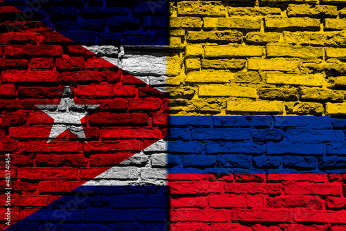 Background with flag of Cuba and Colombia on a brick wall