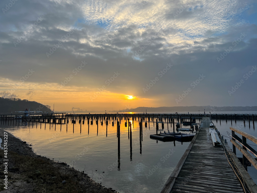 Sunset scene over Baltic sea with empty harbor