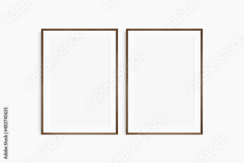 Frame mockup 5x7, 50x70, A4, A3, A2, A1. Set of two thin dark brown walnut wood frames. Gallery wall mockup, set of 2 frames. Clean, modern, minimalist, bright. Portrait. Vertical. Mat opening 2:3.