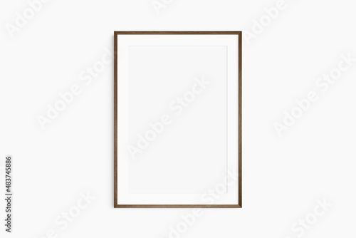 Frame mockup 5x7, 50x70, A4, A3, A2, A1. Single dark brown walnut wood frame mockup. Clean, modern, minimalist, bright. Portrait. Vertical. Passepartout/mat opening in 2:3 aspect ratio.