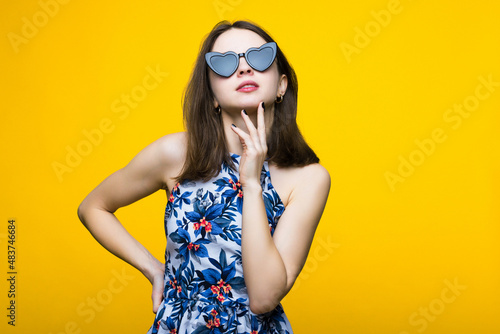 A young woman in a dress and sunglasses