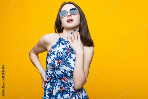 A young woman in a dress and sunglasses