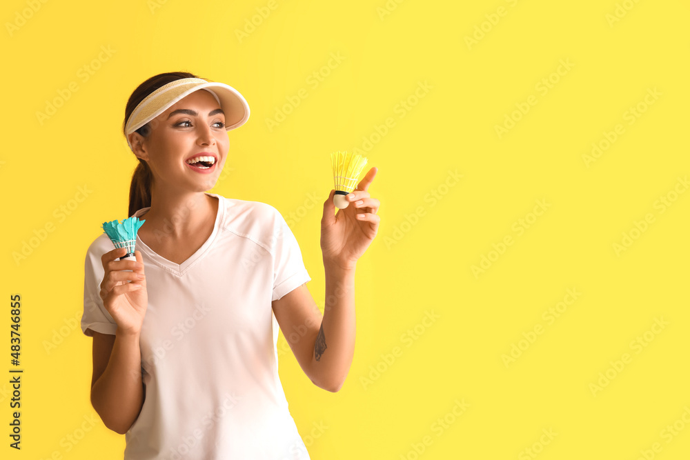 Happy female badminton player on yellow background Happy female badminton player on yellow background