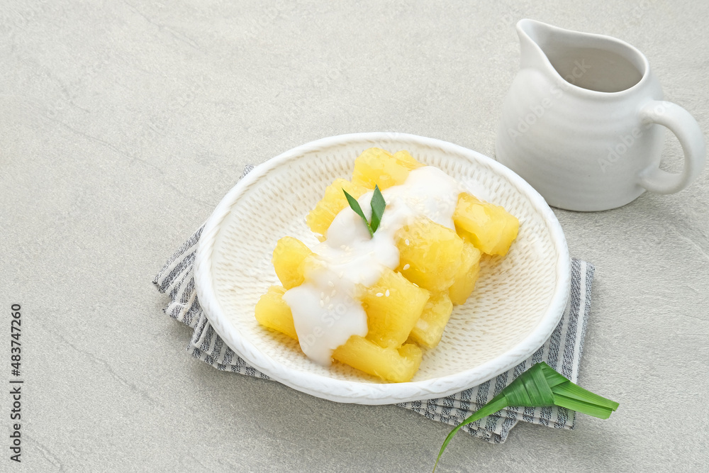 Singkong thailand, sweet cassava, made of boiled cassava, sugar and coconut milk. Served in bowl and pandan leaf, selective focus.
