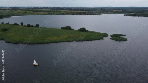 Aerial drone shot of beautiful natural outdoor landscape with blue lake and lonely boat near  Lviv West Ukraine in Eastern Europe on dark cloudy moody summer day. Tourist attraction for sailing.