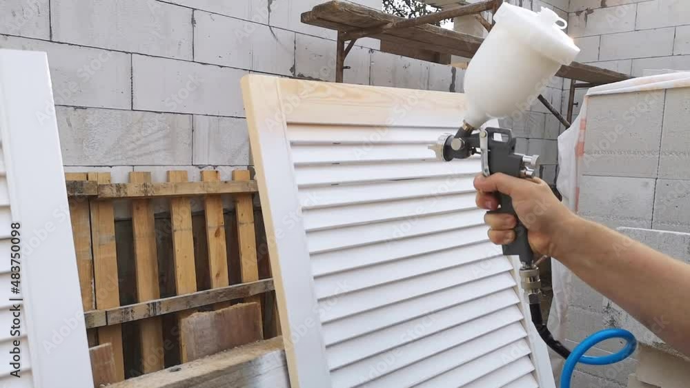 Close-up of a spray gun in a man hand. The process of painting the ...