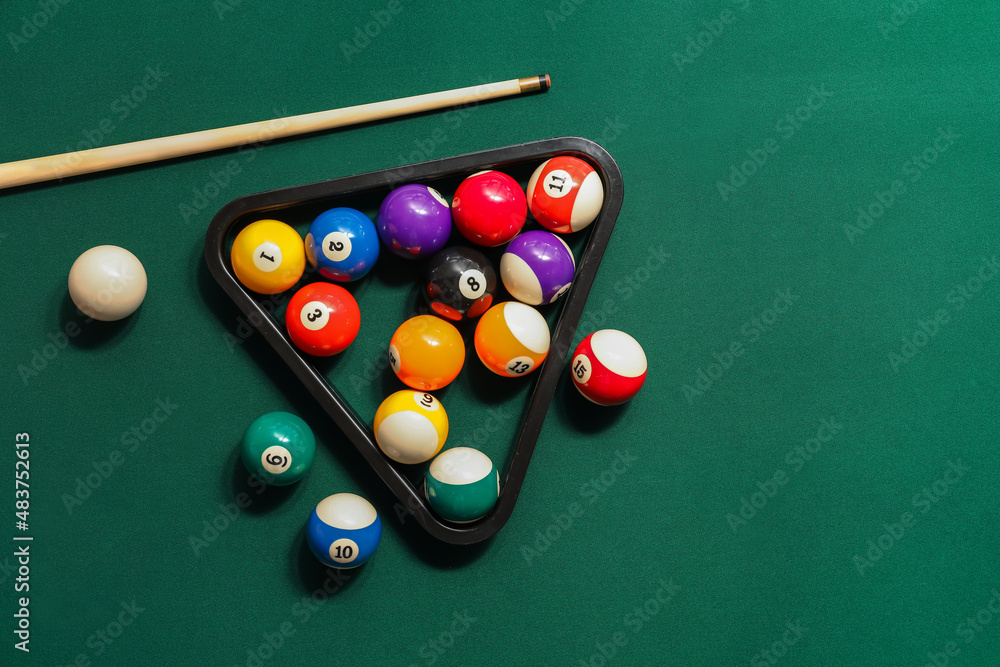 Different billiard balls with cue and rack on green table - obrazy, fototapety, plakaty 