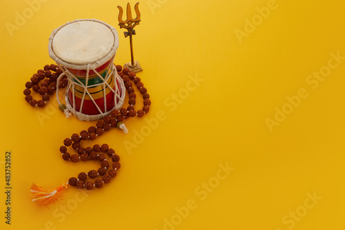 Shivaratri background with Shivas trident and Pellet Drum Damroo musical instrument . Hindu festival Maha Shivratri photo