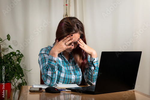Mujer estresada de tanto trabajar con su computadora. Home Office y teletrabajo photo